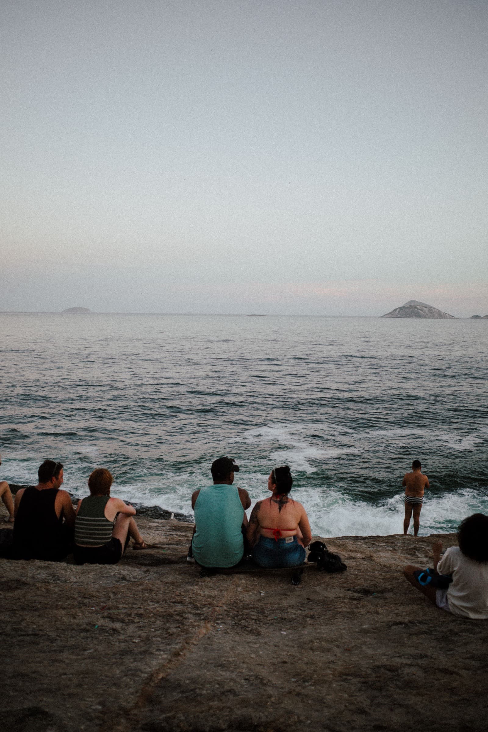 Friends sitting together beside the sea